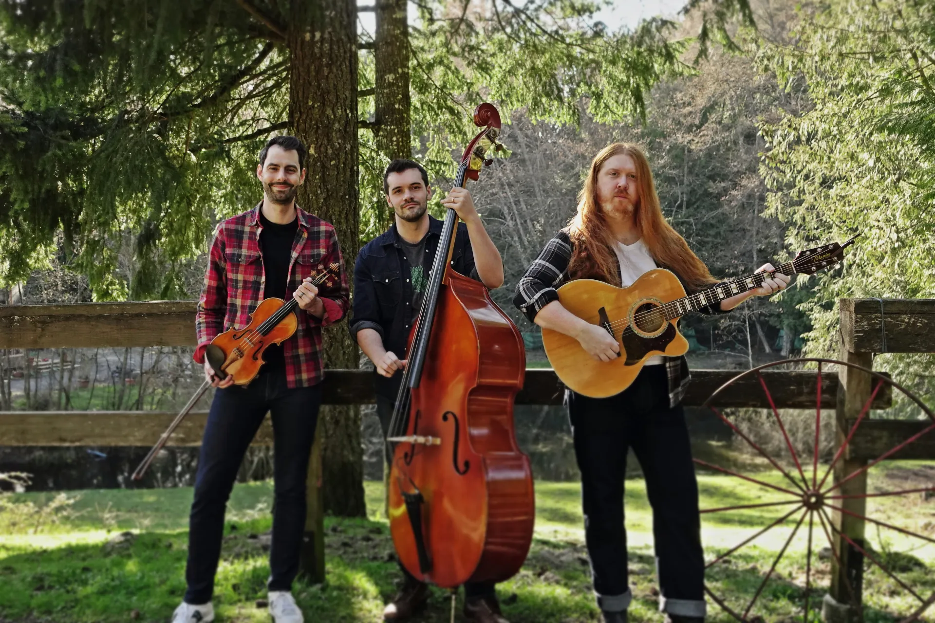 Skookumchuck String Band poses in front of a fence.